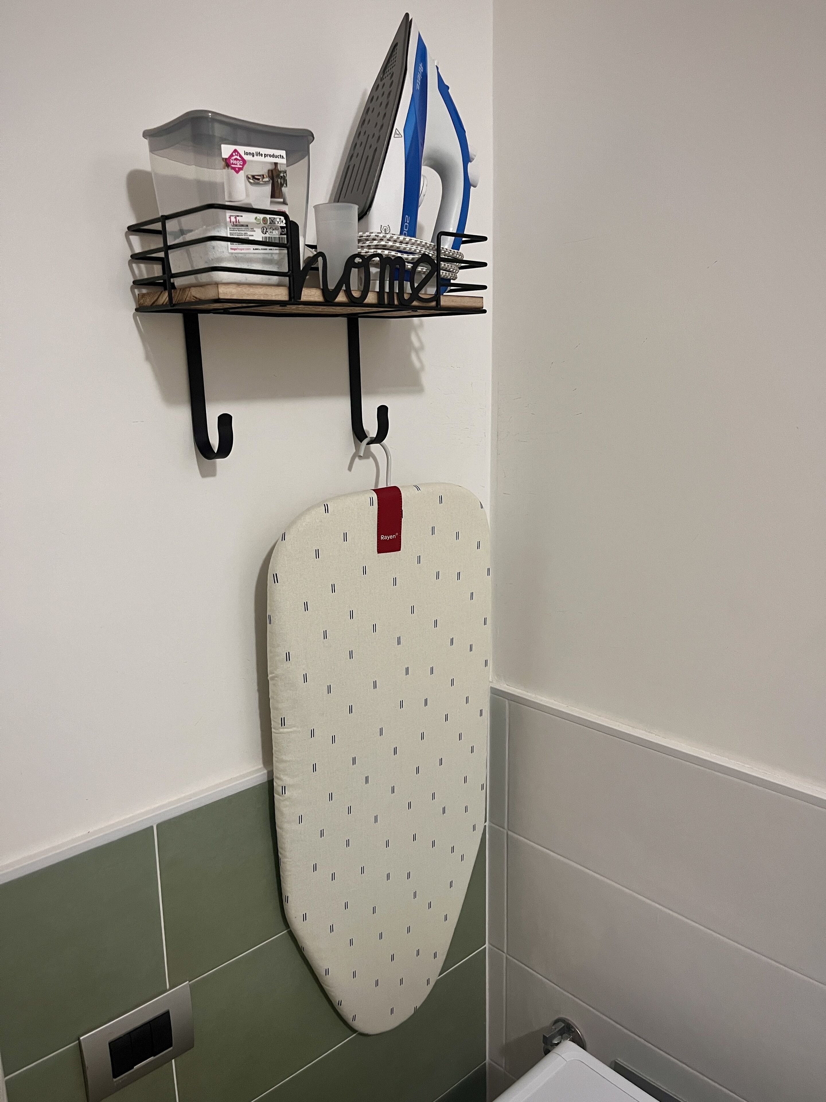 A bathroom with a shower, a towel rack, and a shelf with toiletries.