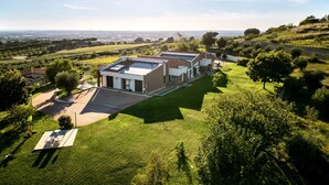 A modern house with a flat roof, large windows, and a spacious lawn. - Cape House (Albano Laziale)