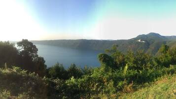 A lake surrounded by hills and dense greenery.