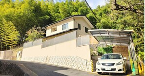 Surrounded by lush greenery, this modern home offers a serene environment with a covered garage and driveway.