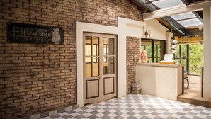 Un área de spa con piso a cuadros, pared de ladrillo, mostrador de recepción y un cartel que dice 'Effleurage Day Spa & Body Care'.