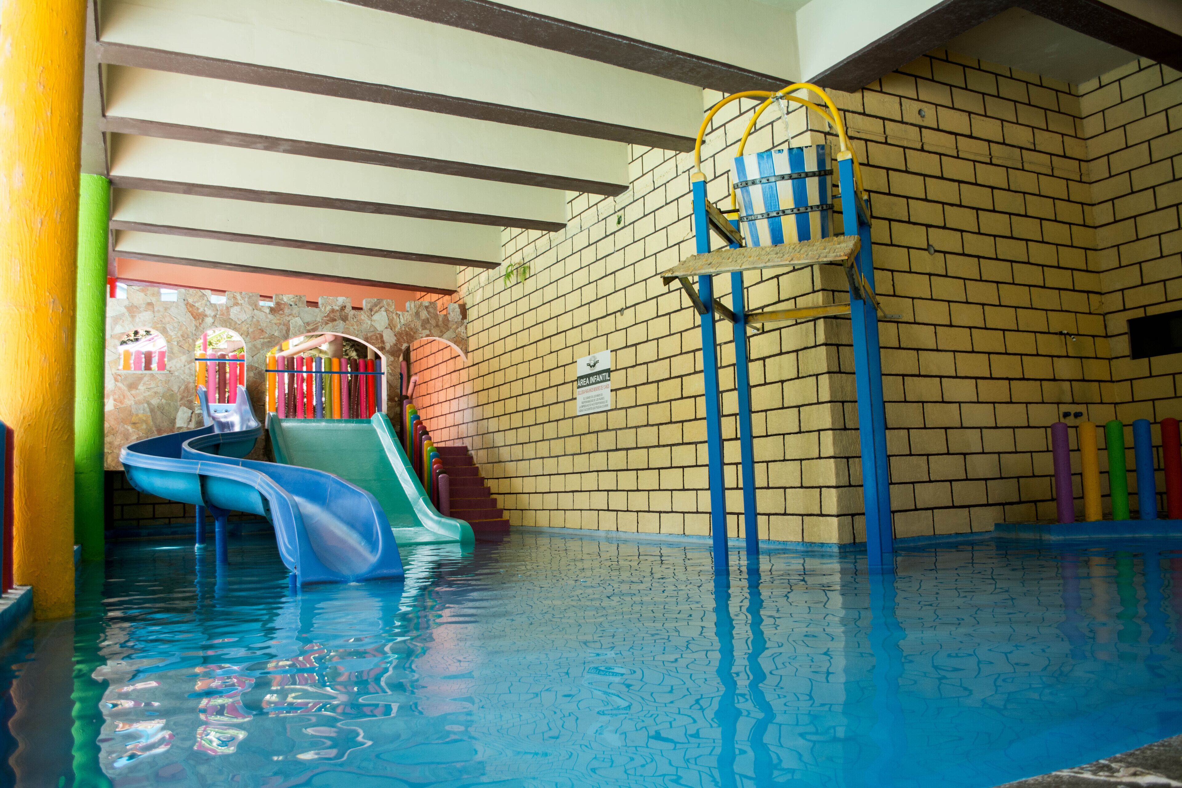 Una piscina interior con toboganes y una escalera.