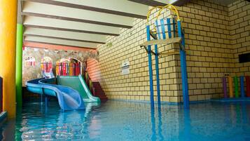 Una piscina interior con toboganes y una escalera.