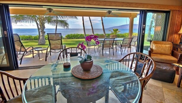 A glass table with chairs and a view of the ocean. - Luxury Oceanfront Escape – King Suite, Large Lanai & 30 Seconds to Beach (Lahaina)