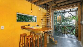 Una escalera de madera que conduce a un balcón con mobiliario para exteriores.