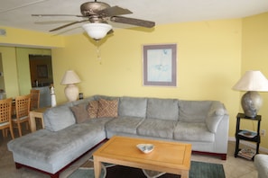 Relax in this stylish living room with a sofa, coffee table, and dining area.