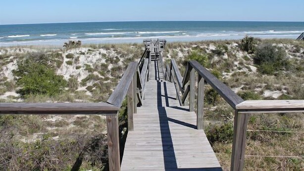 A wooden boardwalk leading to a beach with dunes and the ocean in the background. - Cloud Nine (St. Augustine)