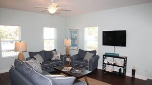 A living room with two sofas, a coffee table, a TV, and a side table with a lamp. - Carlapooh - 2018 New Home (St. Augustine)