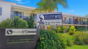 Une affiche pour les appartements Pelican H2O, qui propose à la location des appartements de luxe de 4,5 étoiles avec une ou deux chambres, un décor moderne, des jets privés et un parking couvert.