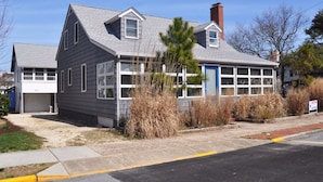 A two-story house with a garage, a blue door, and a chimney. - Ocean Block Rehoboth Beach House Sleeps 10 (Rehoboth Beach)