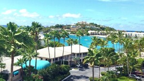 A resort with a large pool, palm trees, and buildings on a hillside. - Cowpet Bay Beach Front Villa with Amazing Views (Elysian Beach Resort)