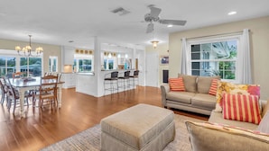 A spacious living room with a sofa, ottoman, and dining area with chairs and a table. - Sarasota Waterfront Paradise- Location, Location...!!
 (Sarasota)