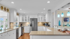 A modern kitchen with white cabinetry, stainless steel appliances, and pendant lighting. - Sarasota Waterfront Paradise- Location, Location...!!
 (Sarasota)