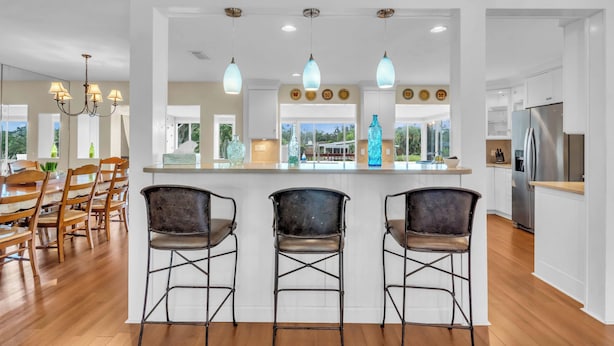 A modern kitchen with a central island, bar stools, and a stainless steel refrigerator. - Sarasota Waterfront Paradise- Location, Location...!!
 (Sarasota)
