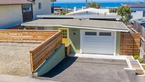 A residential property with a garage, a wooden fence, and a view of the ocean.