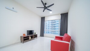 A modern living room with a red sofa, a TV on a wooden stand, a ceiling fan, and a large window with curtains.