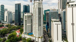 A high-rise building with a unique cylindrical shape, surrounded by other modern skyscrapers.