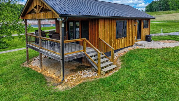 Een houten blokhut met een veranda, een terras en een overdekt buitengebied.