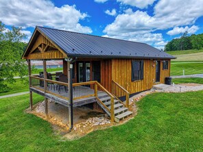 A wooden cabin with a porch, a deck, and a covered outdoor area. - Don's Den Riverfront cabin on the South Holston River (Bristol)