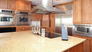 A kitchen with stainless steel appliances, wooden cabinets, and a granite countertop.