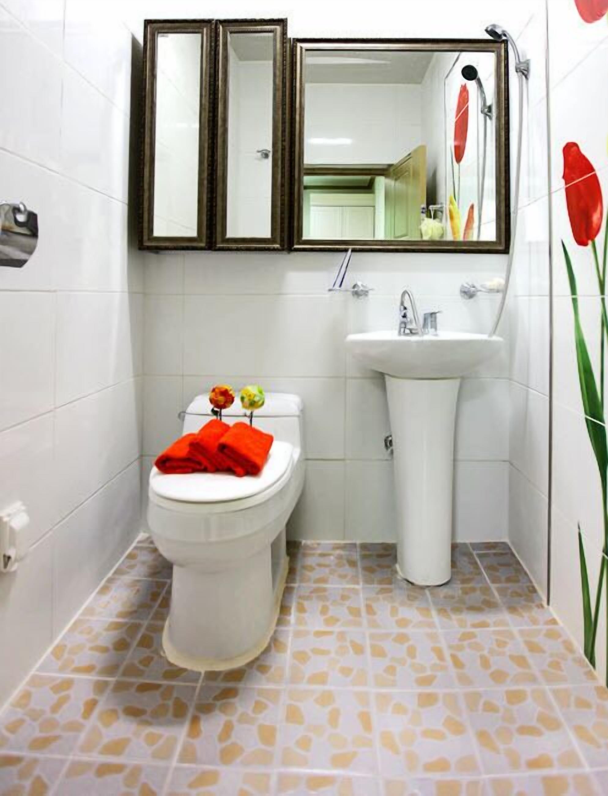 Une salle de bain avec des toilettes, un lavabo et un miroir.