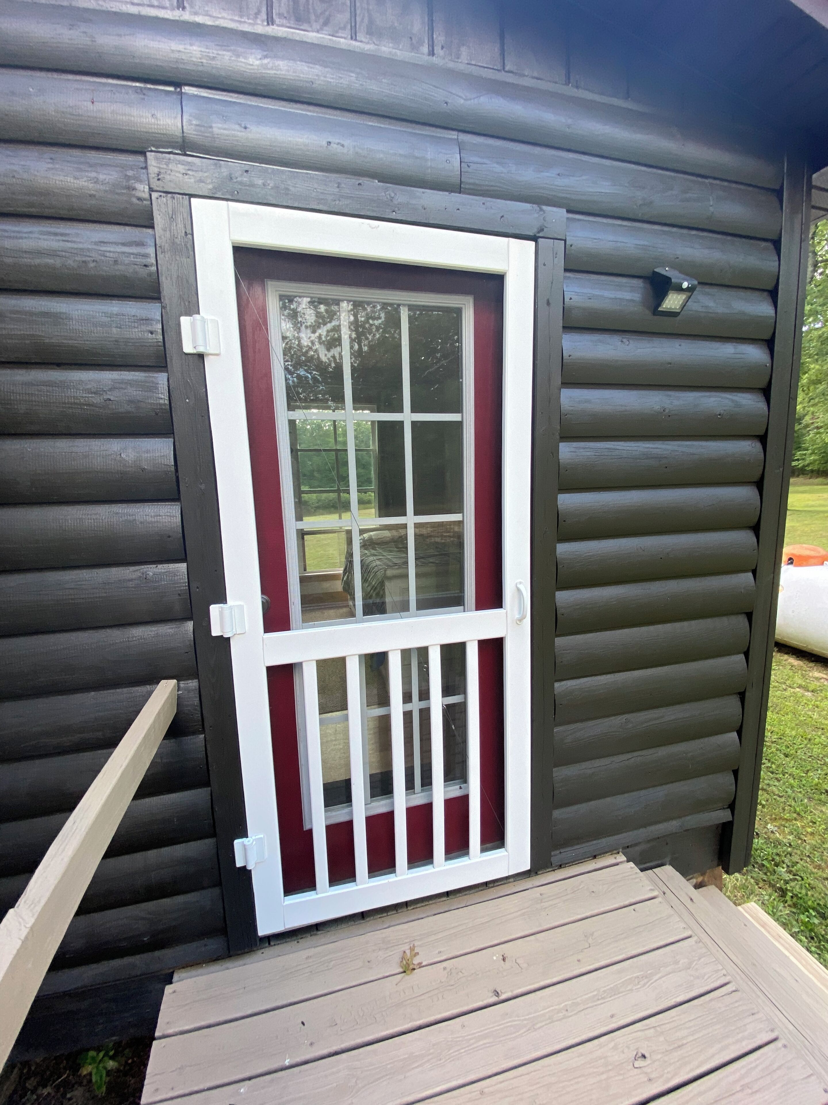 A wooden cabin with a white-framed door and a small porch.
