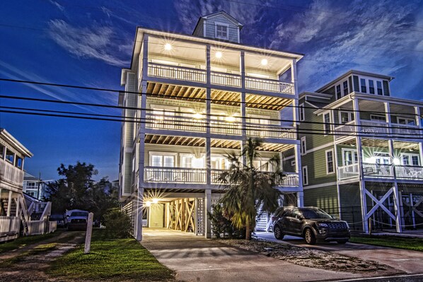 A multi-story residential building with balconies, a garage, and a driveway.
