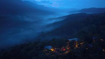 A mountainous landscape with a building surrounded by trees.