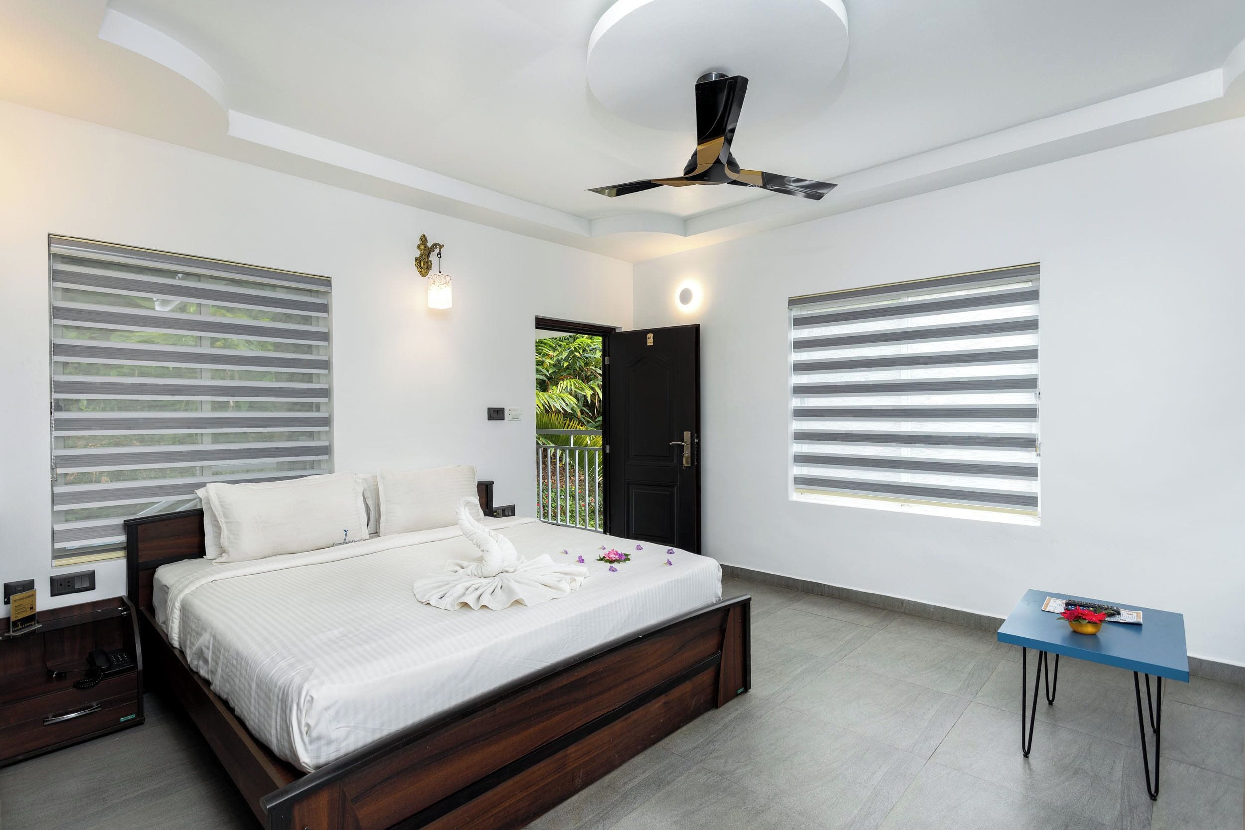 Un dormitorio moderno con cama, mesita de noche y un pequeño escritorio con silla.