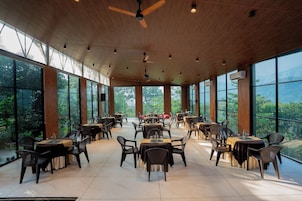 Un comedor espacioso con techos altos, ventanas amplias y vistas al exterior.