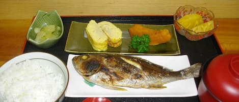 Un plato con arroz, pescado y verduras en una bandeja.