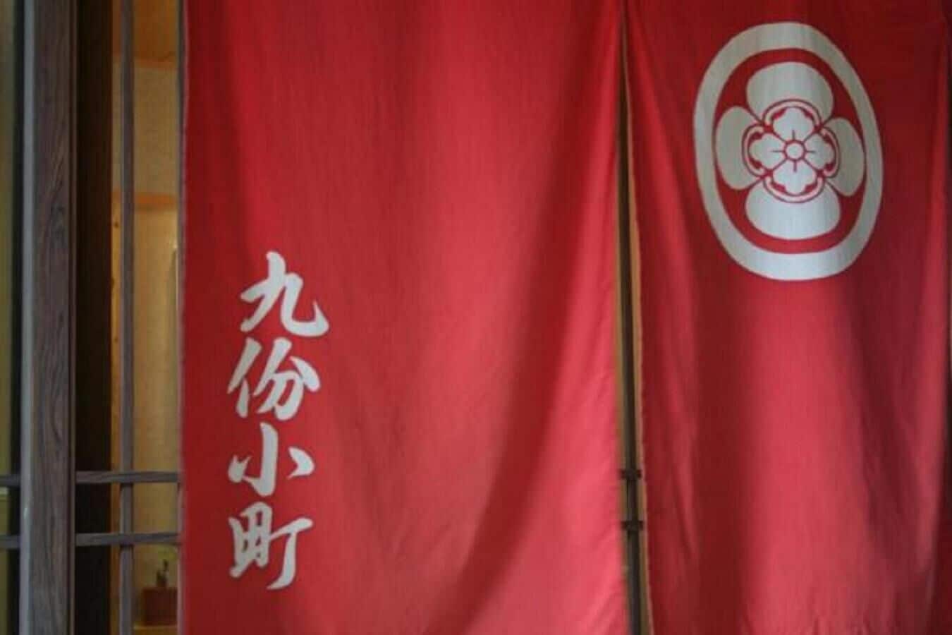 Ein roter Banner mit weißem Text und einem weißen Emblem.