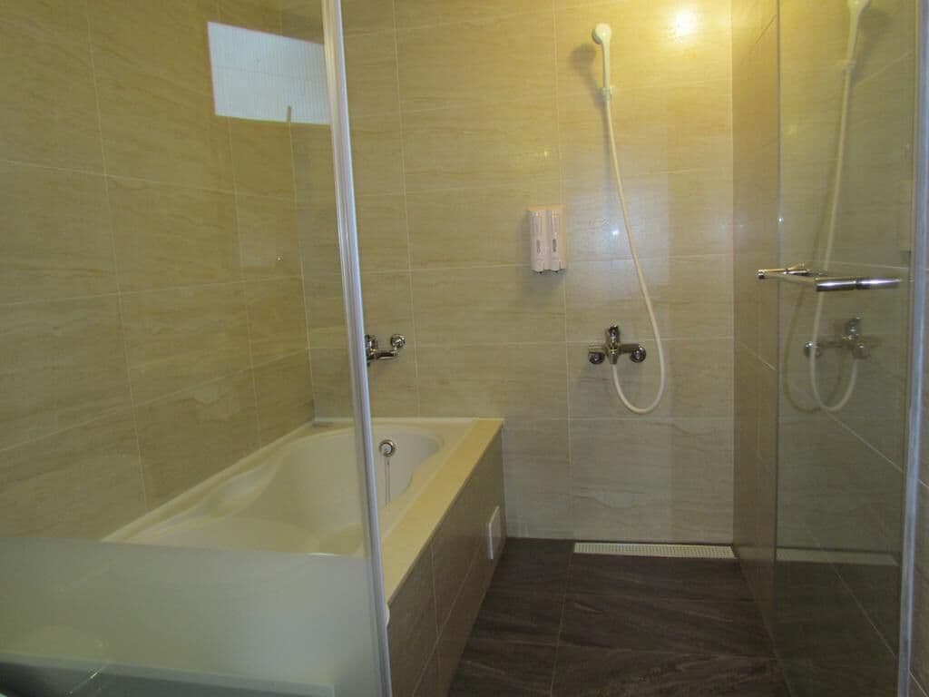 Ein Badezimmer mit Badewanne, Dusche und einer gläsernen Duschkabine.