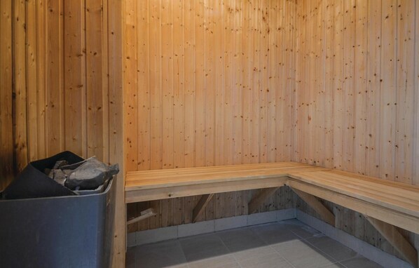 A sauna room with wooden walls and benches. - 8 bedroom stunning home in Ebeltoft (Ebeltoft)