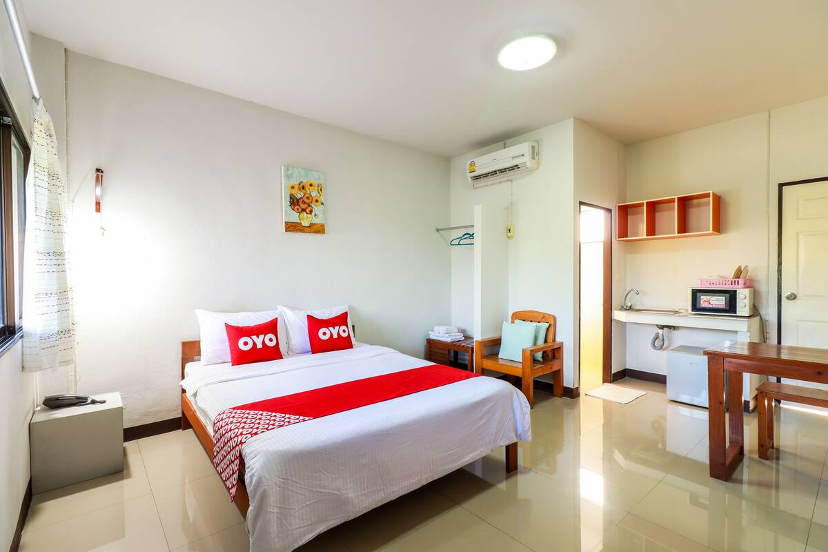 Une chambre d’hôtel équipée d’un lit, d’un bureau, d’une chaise, d’un four à micro-ondes et d’un lavabo.