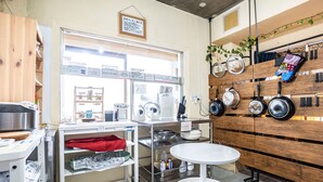 A kitchen with wooden cabinets, a white countertop, and a hanging pot rack.