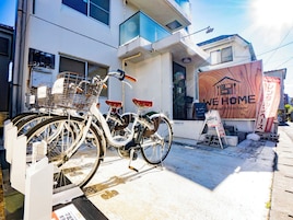 Una bicicleta estacionada frente a un edificio con un letrero que dice "WE HOME Hostel & Kitchen".