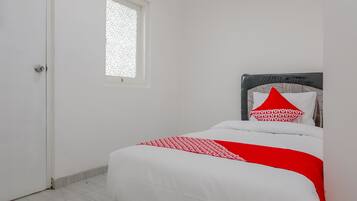 Um quarto com uma cama, janela e porta.