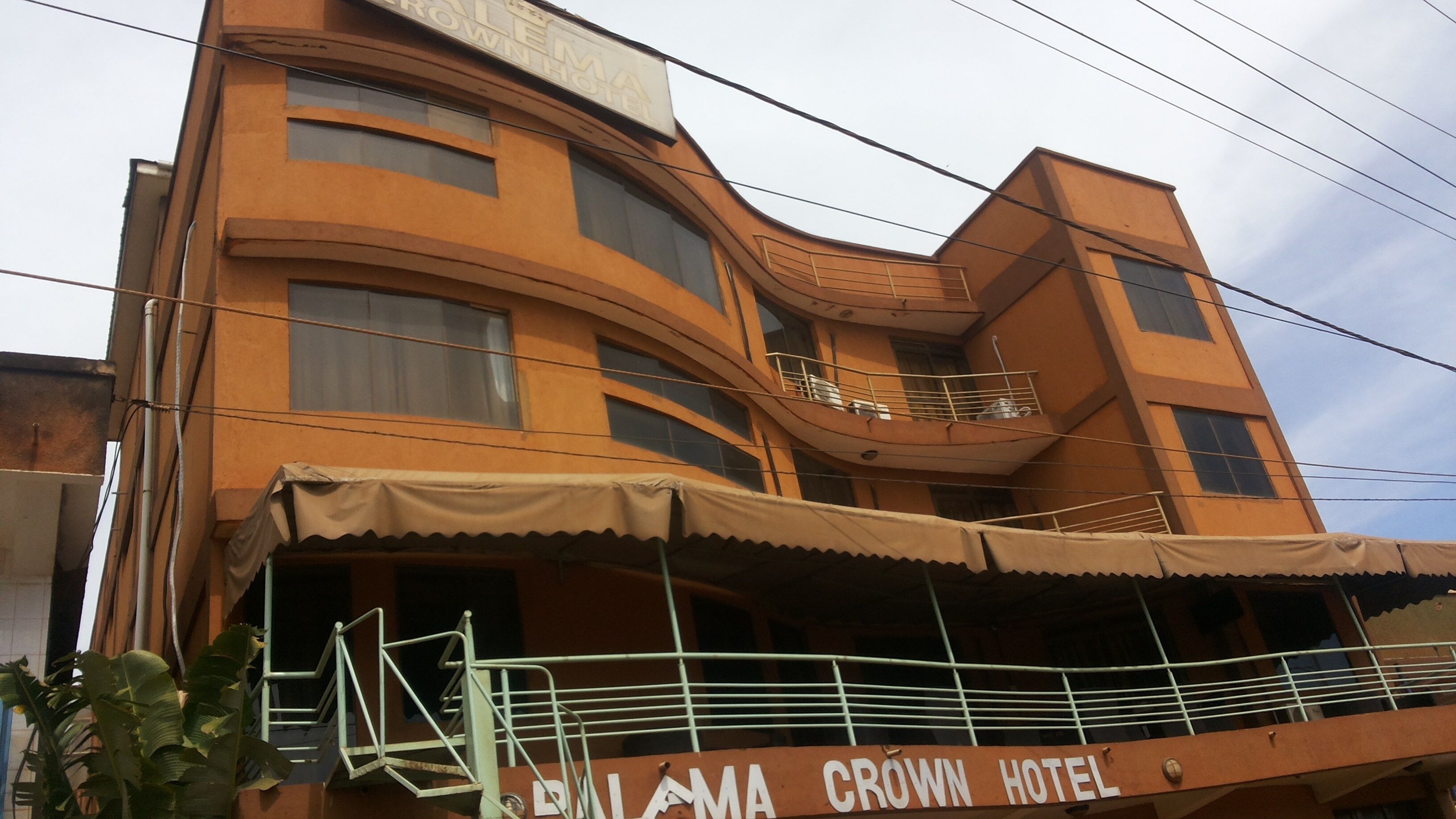 A multi-story building with a sign reading "BAYAMA CROWN HOTEL".