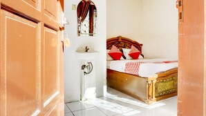 Una habitación con una cama, un lavabo blanco y un espejo.