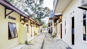 Un estrecho callejón entre edificios con suelo de baldosas y vigas de madera.