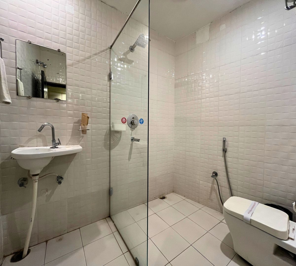 Un baño con lavamanos, cabina de ducha de vidrio y un inodoro.