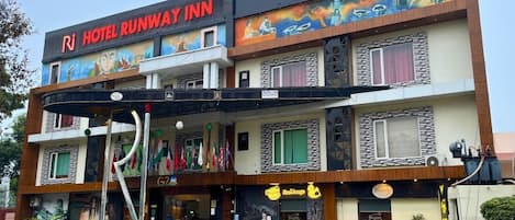 Un hotel de varios pisos con un letrero llamativo que dice "HOTEL RUNWAY INN".