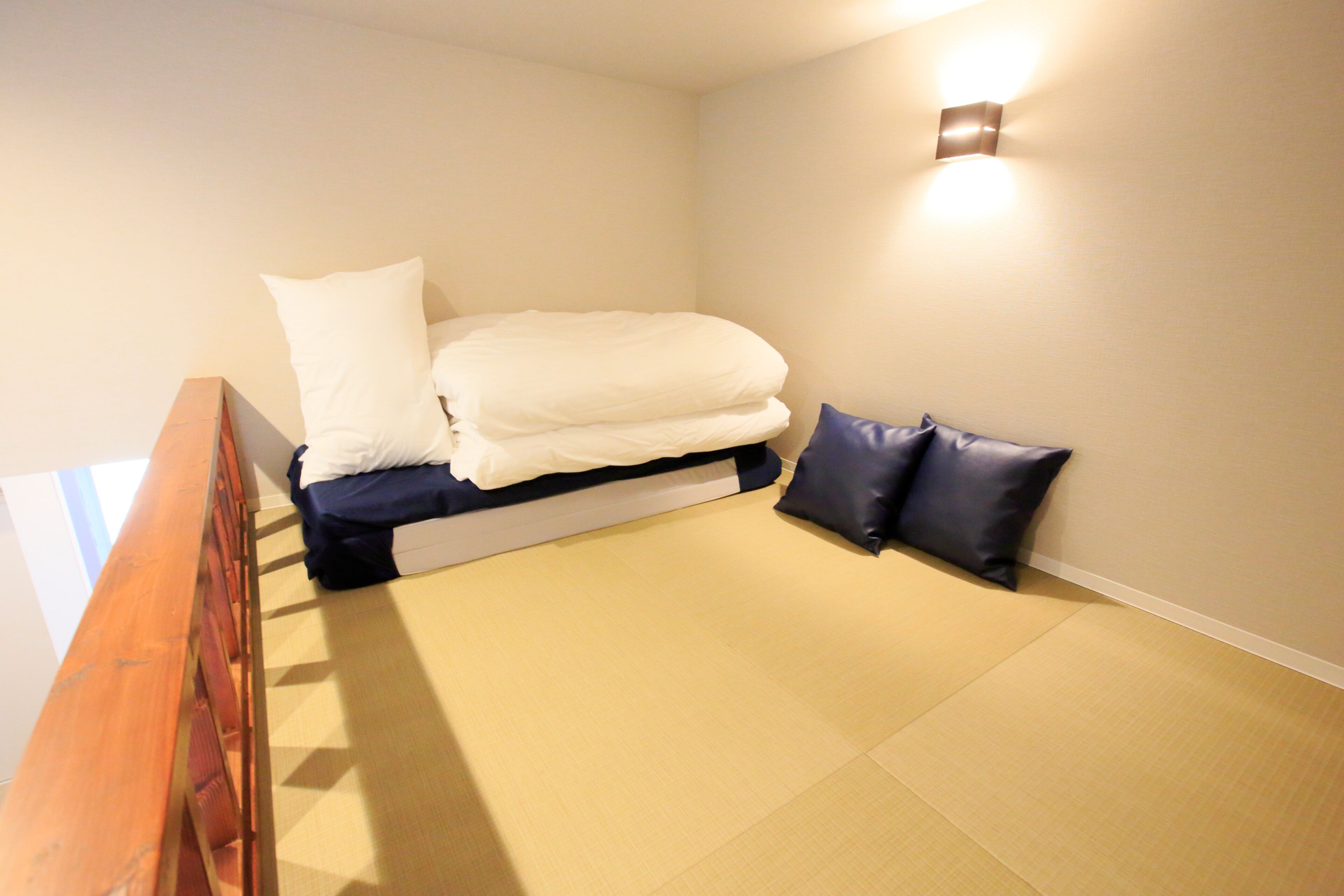 Ein Schlafzimmer mit einem Bett, Kissen und einer wandmontierten Leuchte.