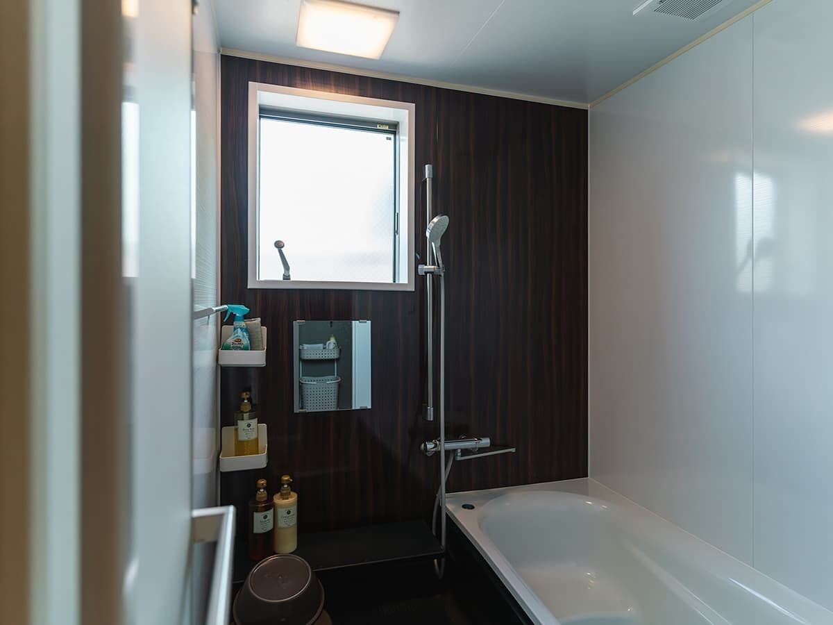 Un baño moderno con bañera, ducha y ventana.
