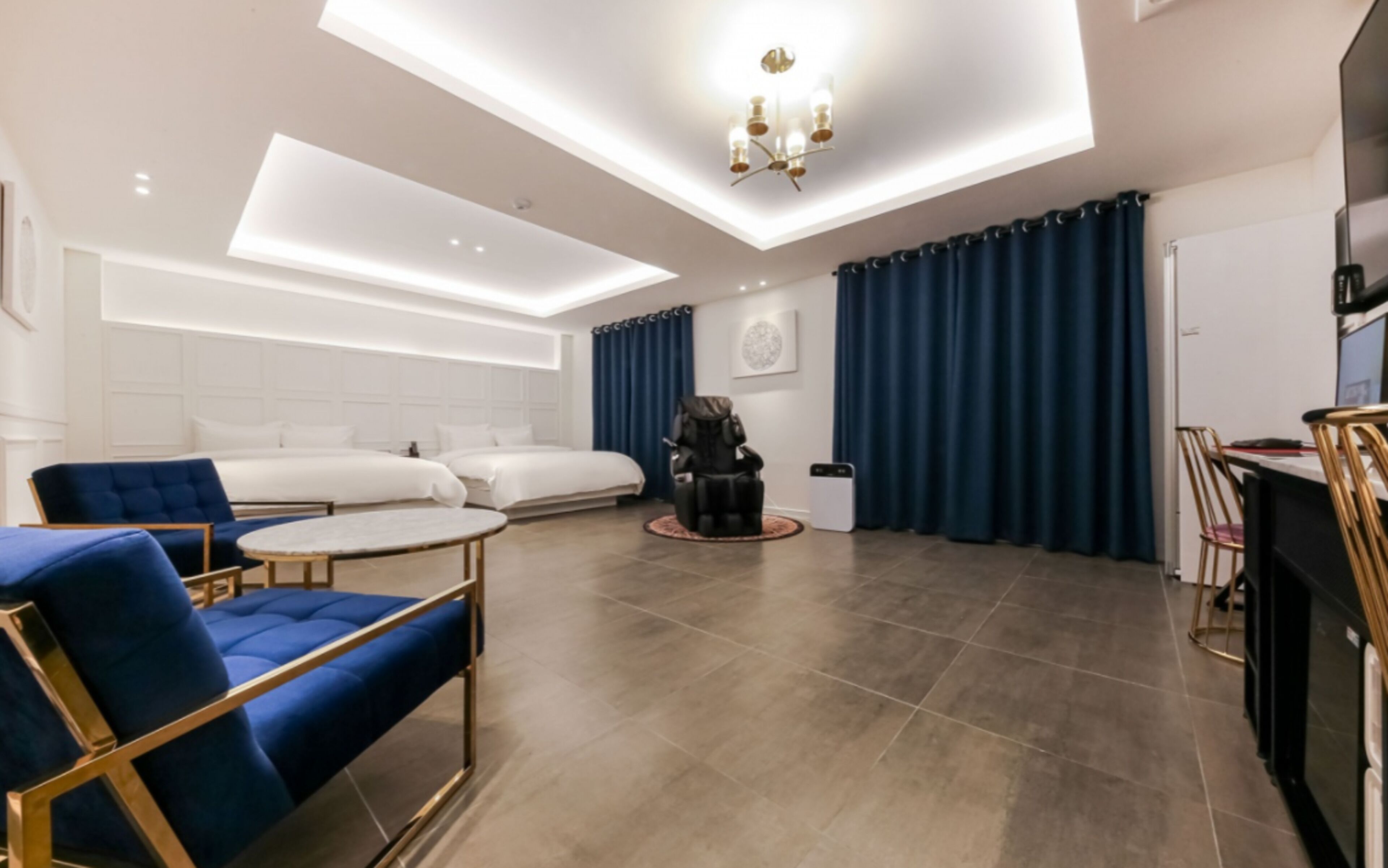 A modern living room with a sofa, a chair, a coffee table, and a dining area with a chair and table.