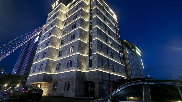 Un hotel de varios pisos con fachada en zigzag, iluminado por luces interiores.