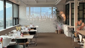 Un espacio de oficina moderno con paredes de ladrillo blanco, ventanas amplias y vista a la ciudad.