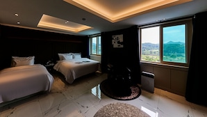 Una habitación de hotel moderna con dos camas, un ventanal con vistas al campo y un techo con iluminación empotrada.