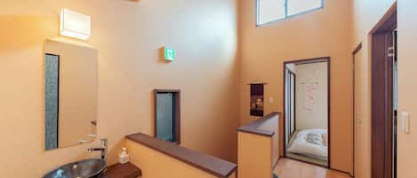 A bathroom with a large mirror, a sink, and a towel rack.
